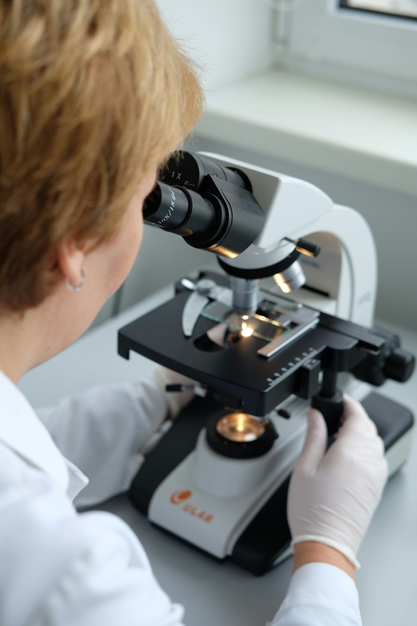 Laboratory scientist examining samples under a microscope